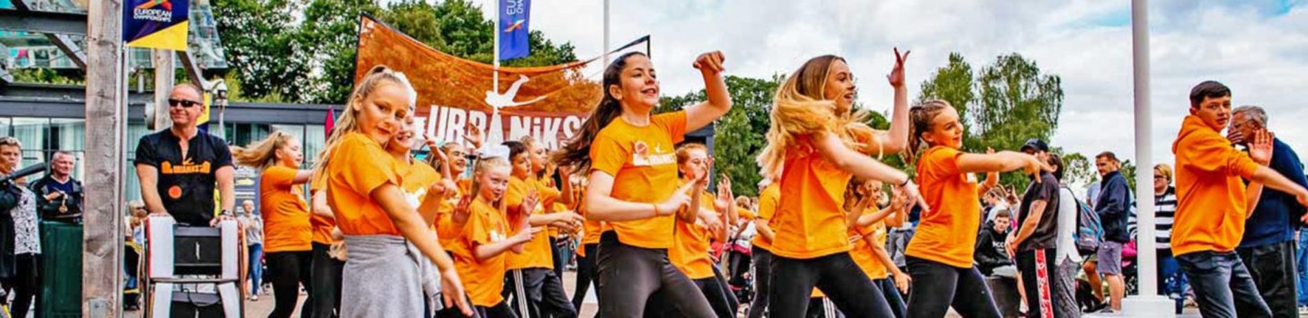 young-girls-and-boy-dressed-in-orange-t-shirts-dancing-at-balloch-festival-event-two-thousand-eighteen