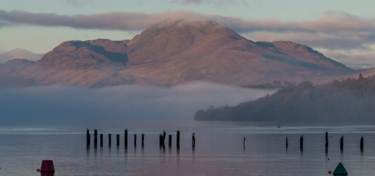 young-people-photo-competition-image-of-ben-lomond-covered-around-its-base-by-wispy-clouds-as-well-as-above-summit-everything-in-late-orange-sunset-light