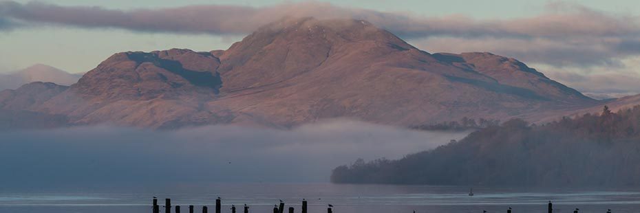 young-people-photo-competition-image-of-ben-lomond-covered-around-its-base-by-wispy-clouds-as-well-as-above-summit-everything-in-late-orange-sunset-light