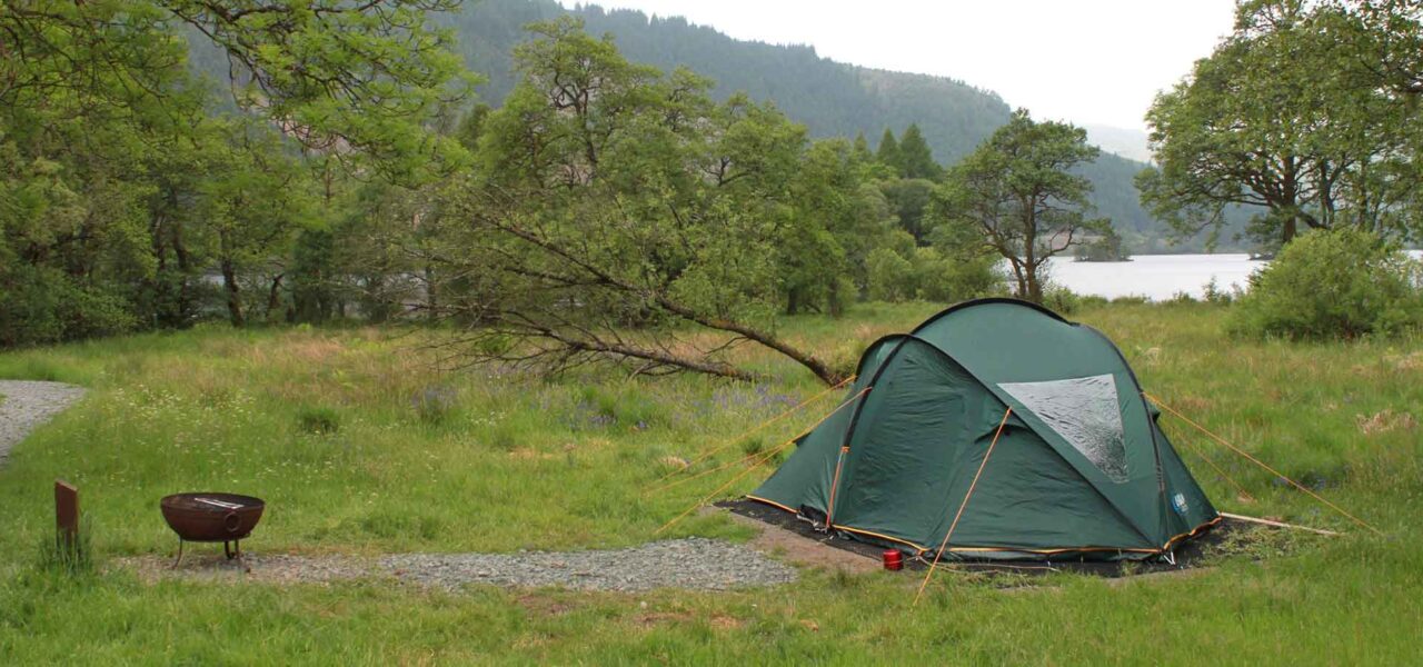 loch-chon-campsite-pitch-number-four-green-tent-with-fire-bowl-outside-entrance-and-loch-and-trees-visible-in-the-background
