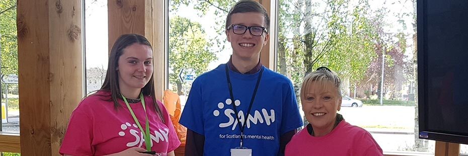 three-national-park-staff-dressed-in-pink-and-blue-samh-t-shirts-raising-money-for-charity-scottish-association-for-mental-health