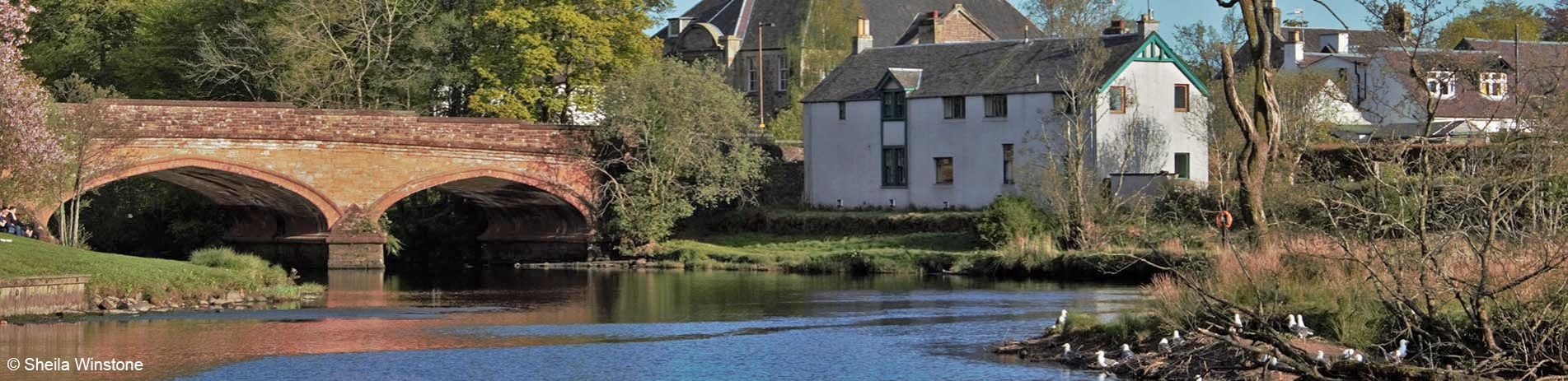 red-sandstone-beach-over-river-teith-in-callander-with-white-houses-on-its-right