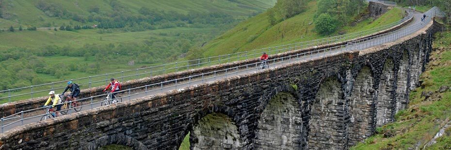 glen-ogle-viaduct-with cyclists-on-their-bike-peddling-over