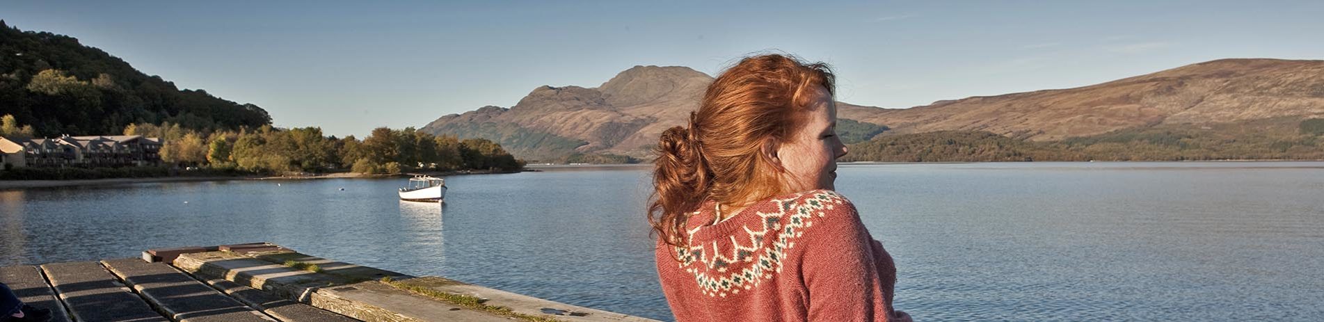 ginger-girl-in-pink-sweater-admiring-view-of-loch-lomond-from-luss-pier