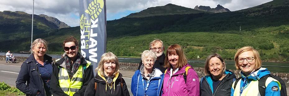 group-of-walkers-in-outdoor-gear-with-cobbler-and-arrochar-alps-mountains-in-the-distance