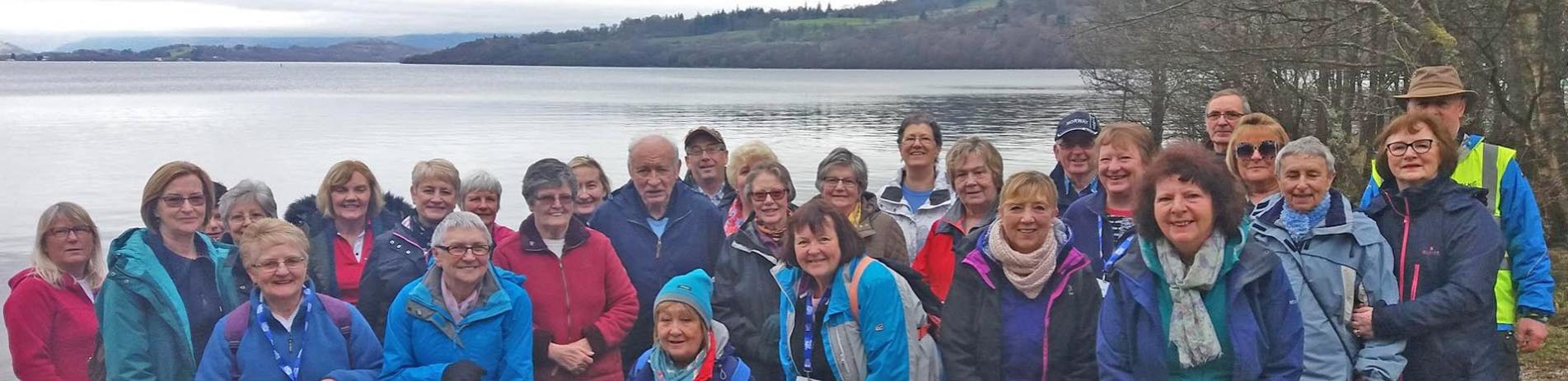 group-of-elderly-in-outdoor-jackets-part-of-walking-group-at-the-edge-of-loch-lomond