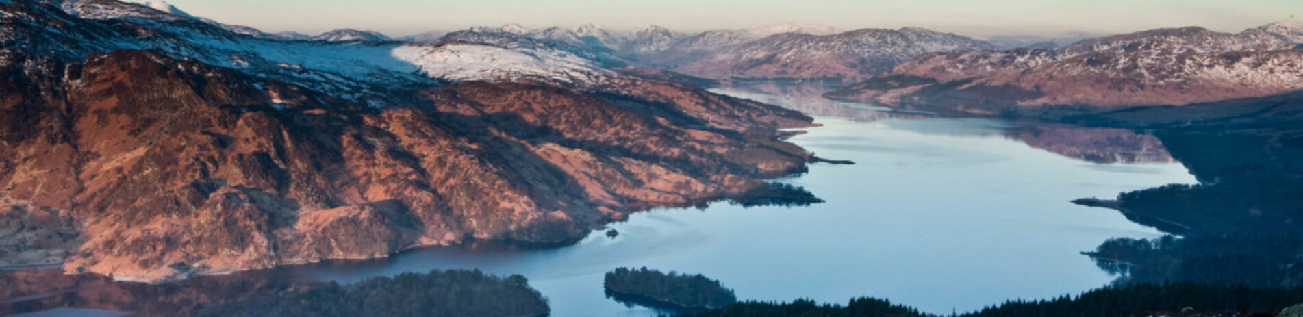 aerial-view-of-trossachs-mountains-covered-by-snow-on-summits-and-loch-katrine-taken-from-ben-aan