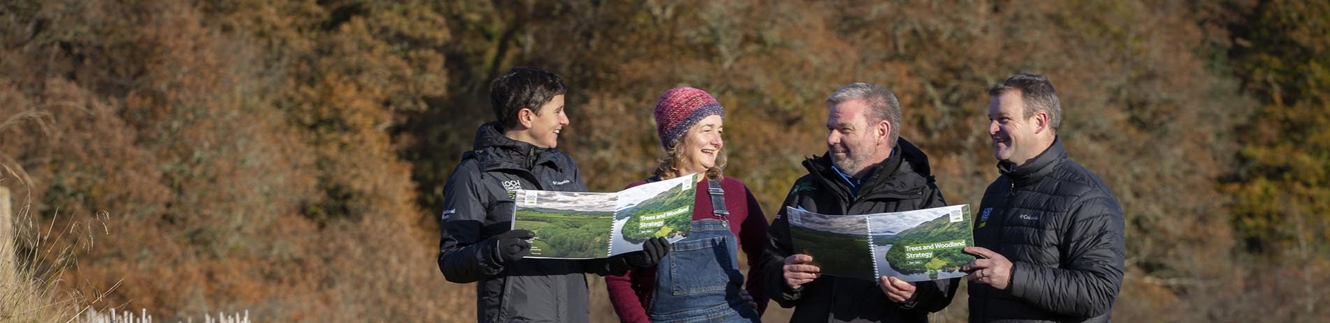 photo-call-at-achray-farm-brig-o-turk-near-callander-for-the-launch-of-the-national-park-trees-and-woodland-strategy-pictured-four-people-holding-the-strategy-booklet-open-with-trees-in-the-background
