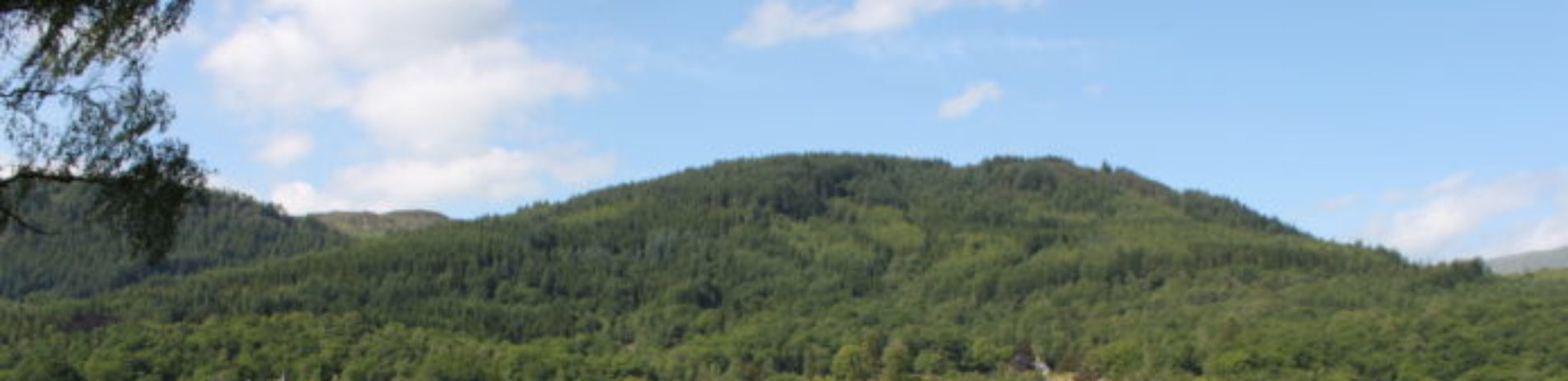 loch-achray-seen-from-campsite-on-a-sunny-day-with-forested-hills-in-the-distance