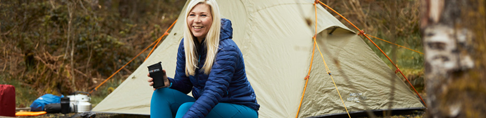 blonde-woman-smiling-in-front-of-tent