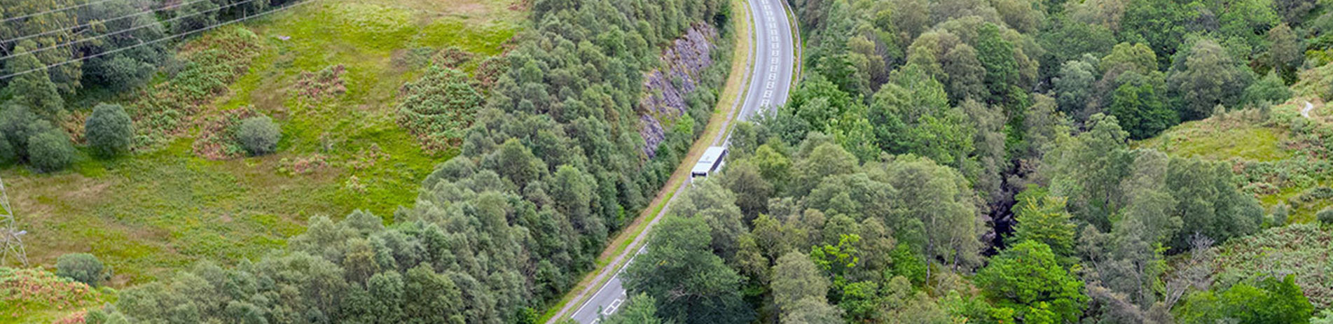 bus-travelling-along-road-next-to-falls-of-falloch