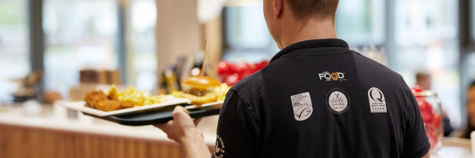 man serving chips in the Real Food Cafe in Tyndrum