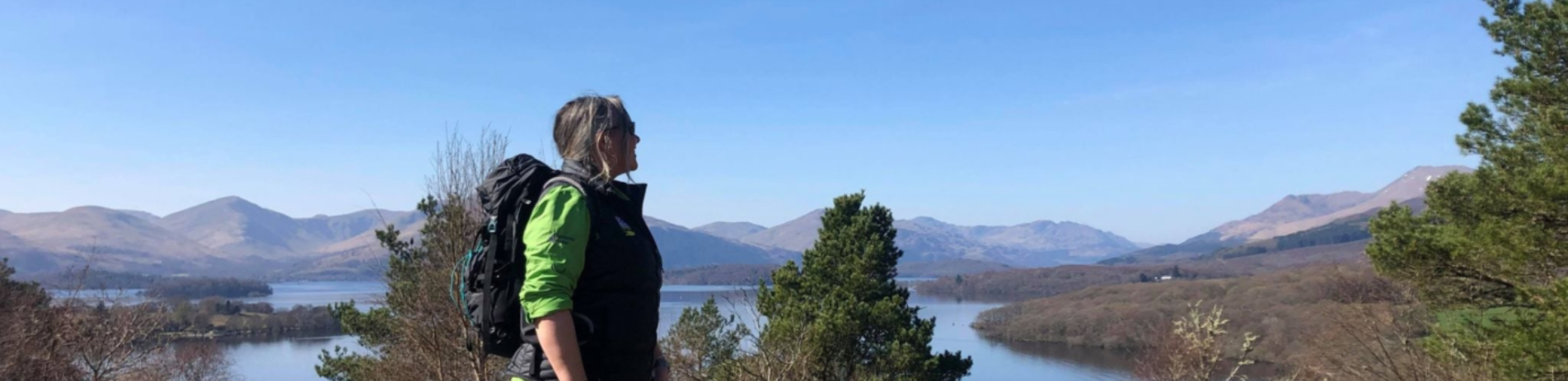 Ranger Louise Milne looking out at a view of lochs and hills at Craigie Fort