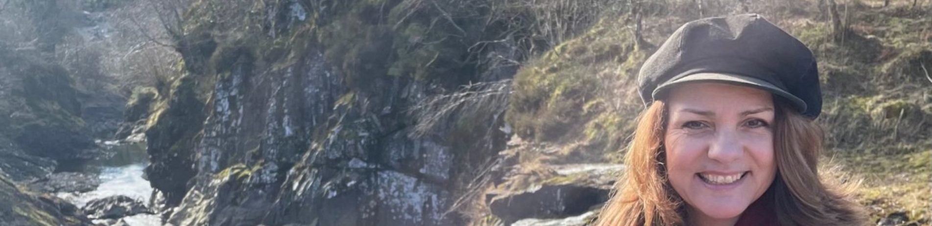 National Park Board Conevor Heather Reid standing at Bracklinn Falls with water and rocks in the background