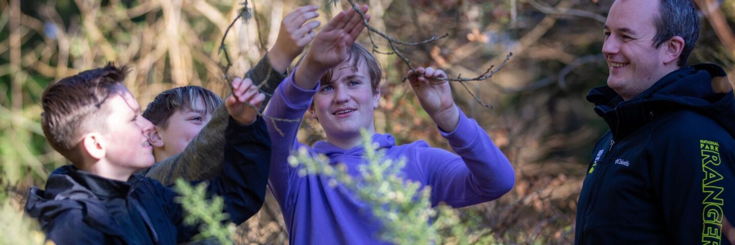 Hero-three-children-looking-at-tree-branches-with-a-National-Park-Ranger.jpg