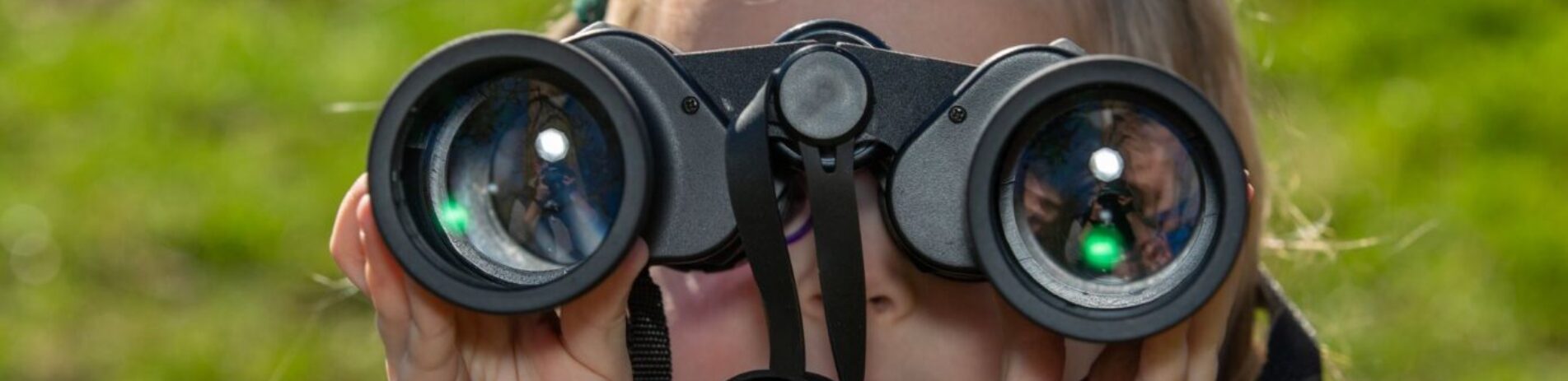 close up of child holding binoculars