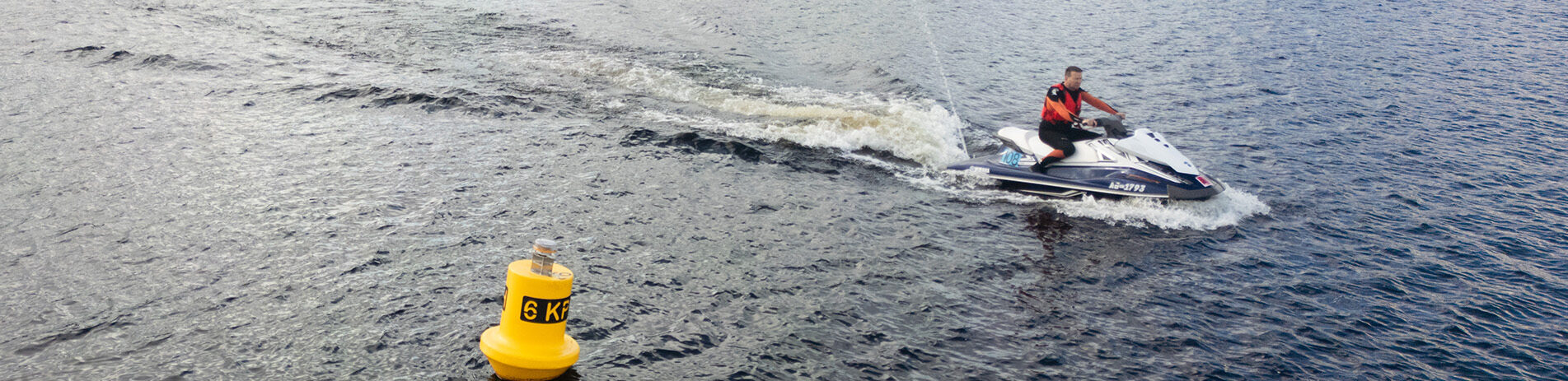Loch user on jetski, motoring slowly past a 6kph buoy