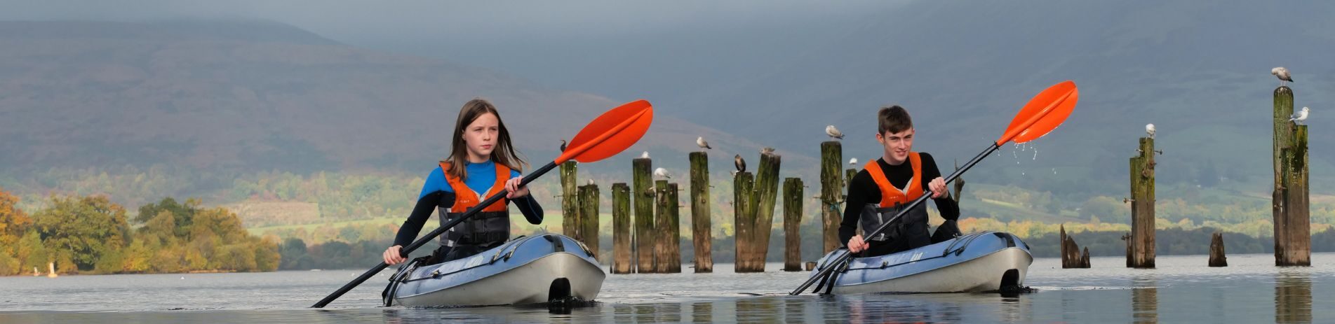 two children who look under 16 in kayaks wearing life jackets