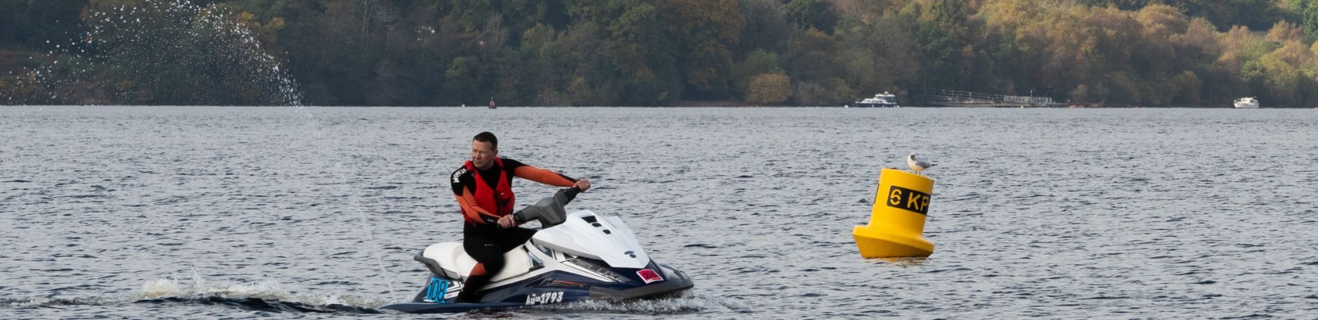 Person on a jet ski with a yellow buoy in the background